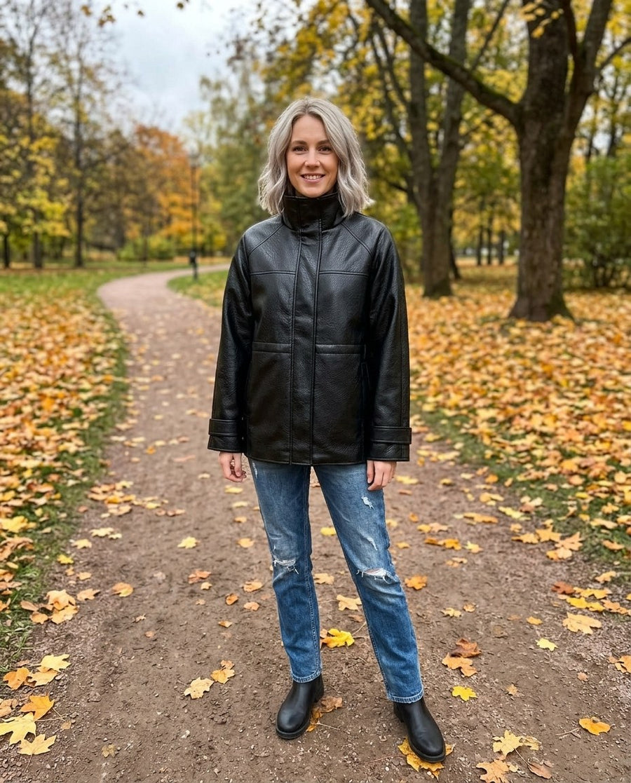 Astrid, jacka i skinnimitation med hög krage för dam i svart, stylinginspiration i en höstpark