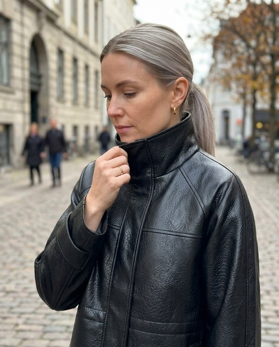 Astrid, jacka i skinnimitation med hög krage för dam i svart, stylinginspiration närbild på materialet