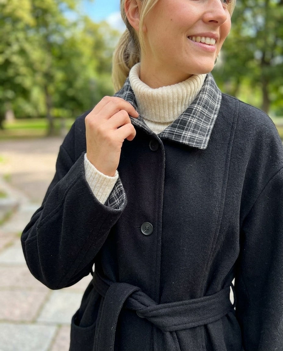 Greta, kappa med skärp och kontrastkrage för dam i svart, stylinginspiration närbild på materialet