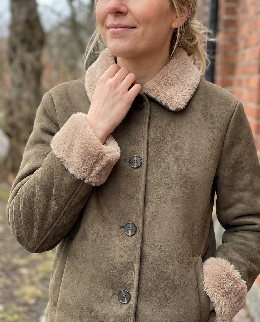 Elsa, kort damjacka i mockalook med teddykrage i olivbrun, stylinginspiration närbild på materialet