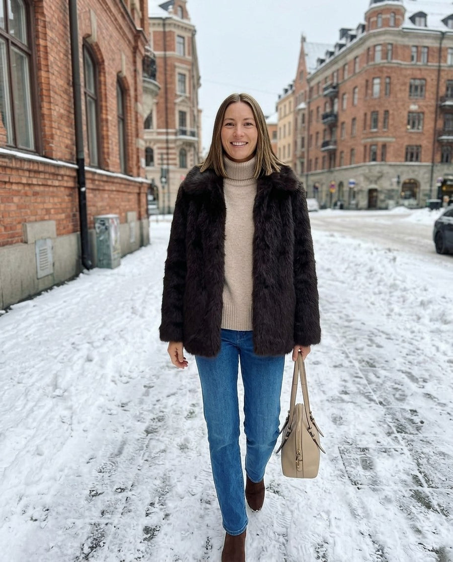 Freja, kort fuskpälsjacka för dam i mörkbrun, stylinginspiration på en snöig gata