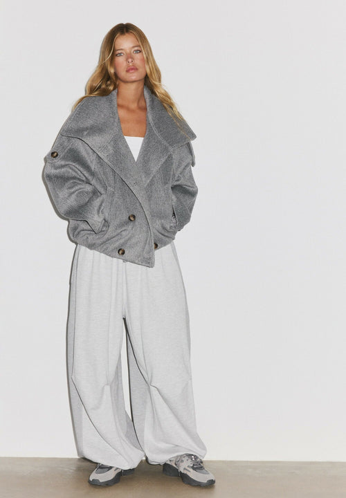 Ylva, kurze graue Jacke zu einer weiten hellgrauen Hose, Ganzkörperansicht