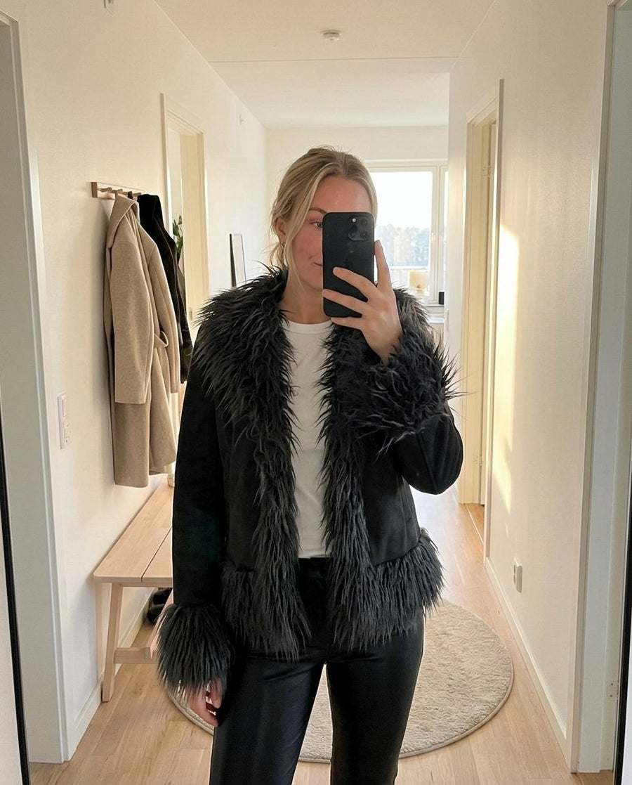 Selma, kort jacka med fuskpälskant för dam i svart, stylinginspiration spegelbild i hallen