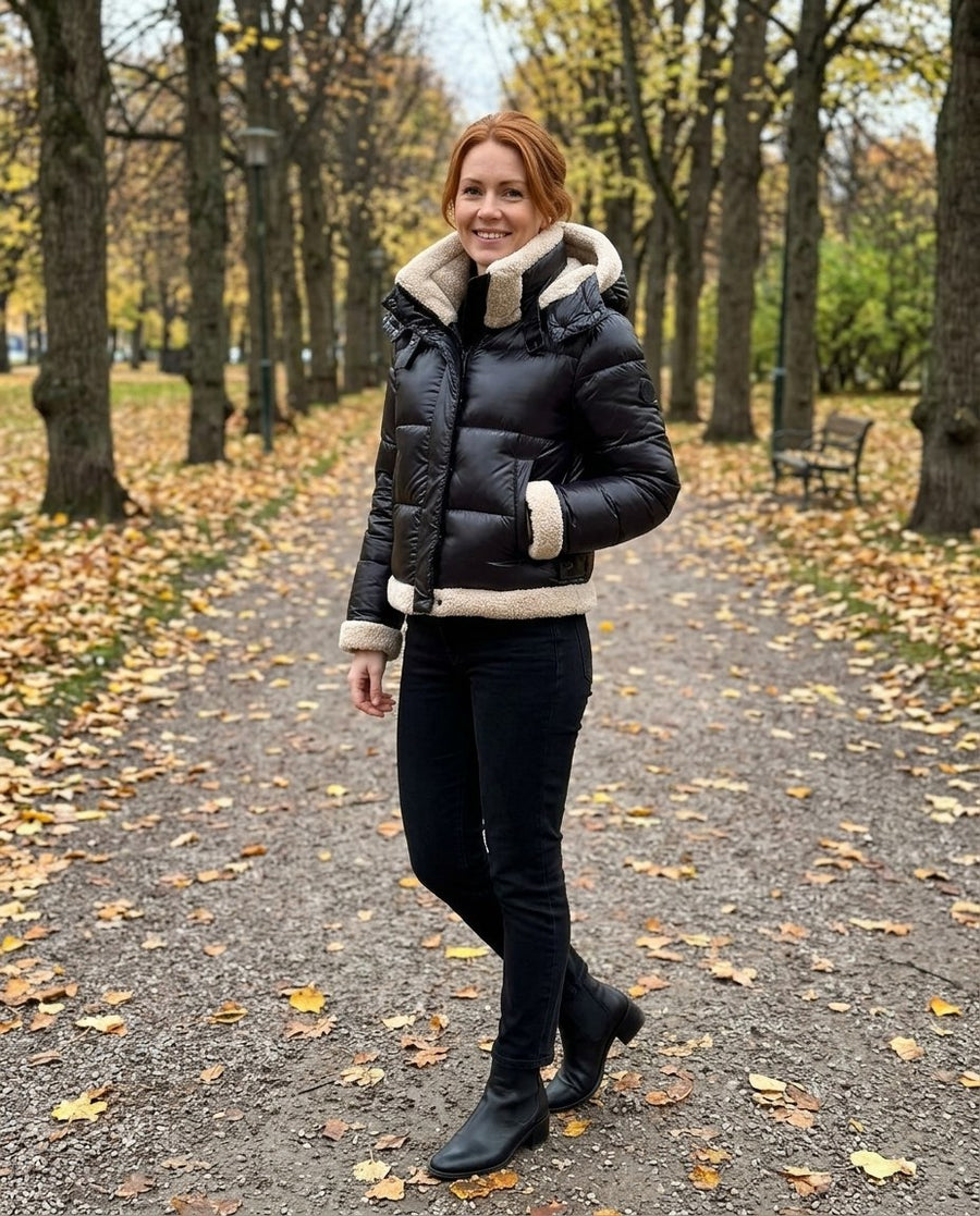 Ingrid, kort pufferjacka med teddyfoder för dam i svart, stylinginspiration i en höstpark