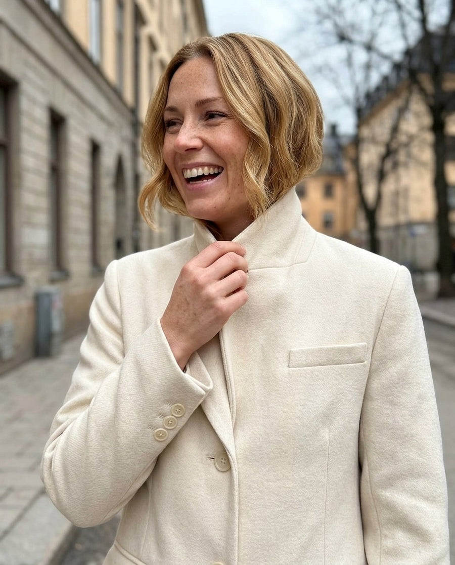 Majken, lång figursydd kappa för dam i ljusbeige, stylinginspiration närbild på materialet