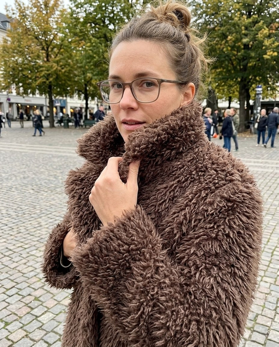 Saga, lång fuskpälskappa för dam i brun, stylinginspiration närbild på materialet
