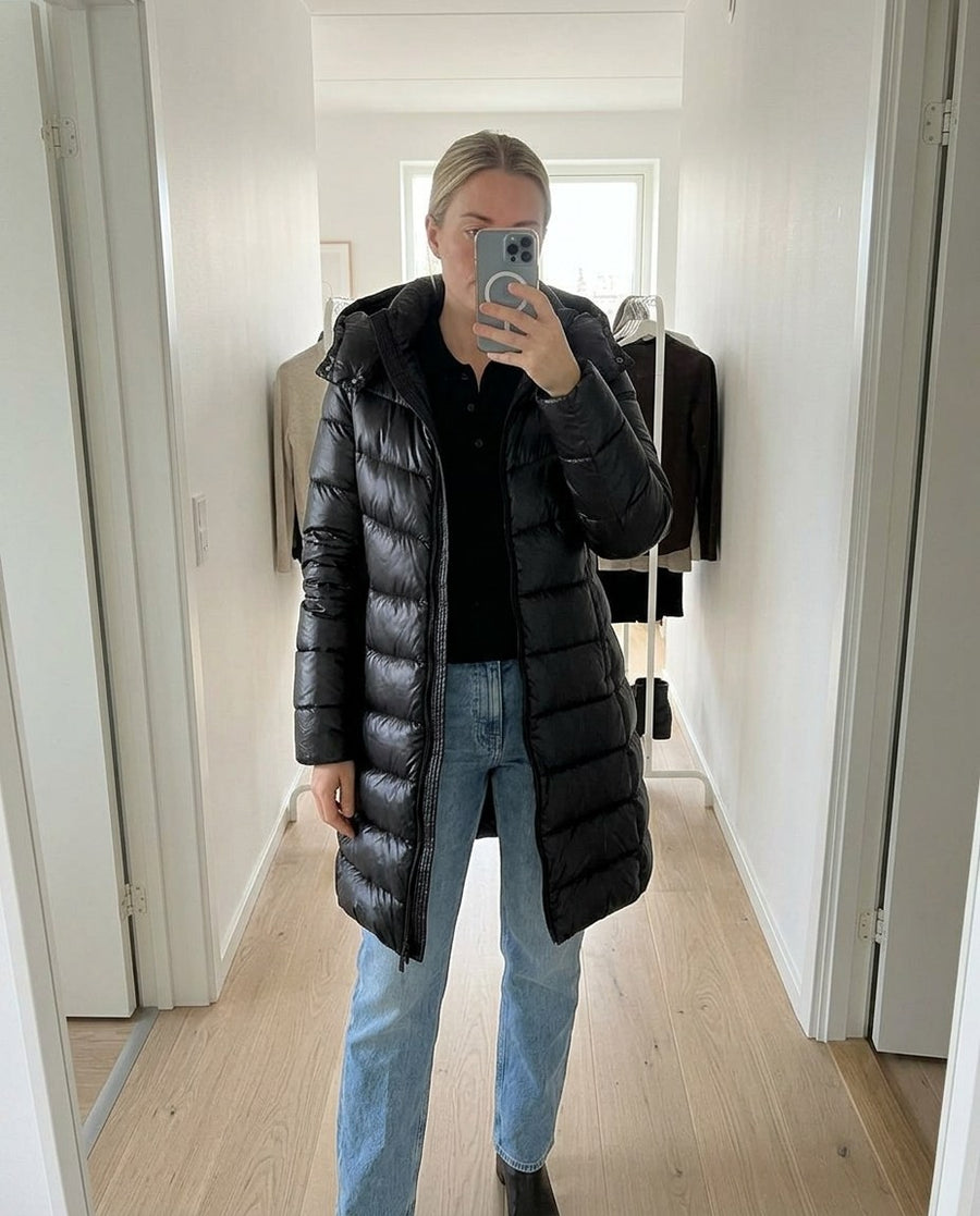 Vera, lång pufferkappa med huva för dam i svart, stylinginspiration spegelbild i hallen