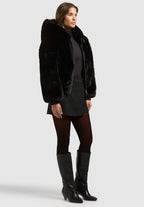 Stina, Kunstfelljacke in Schwarz mit Kapuze, von der Seite
