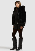 Stina, Kunstfelljacke in Schwarz mit Kapuze, von vorne