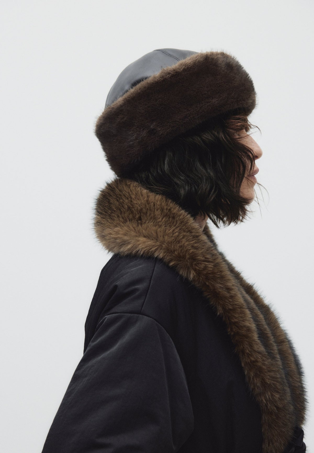 Tilda, wattierte Jacke in Schwarz mit Kunstfellkragen und Bindegürtel, von der Seite