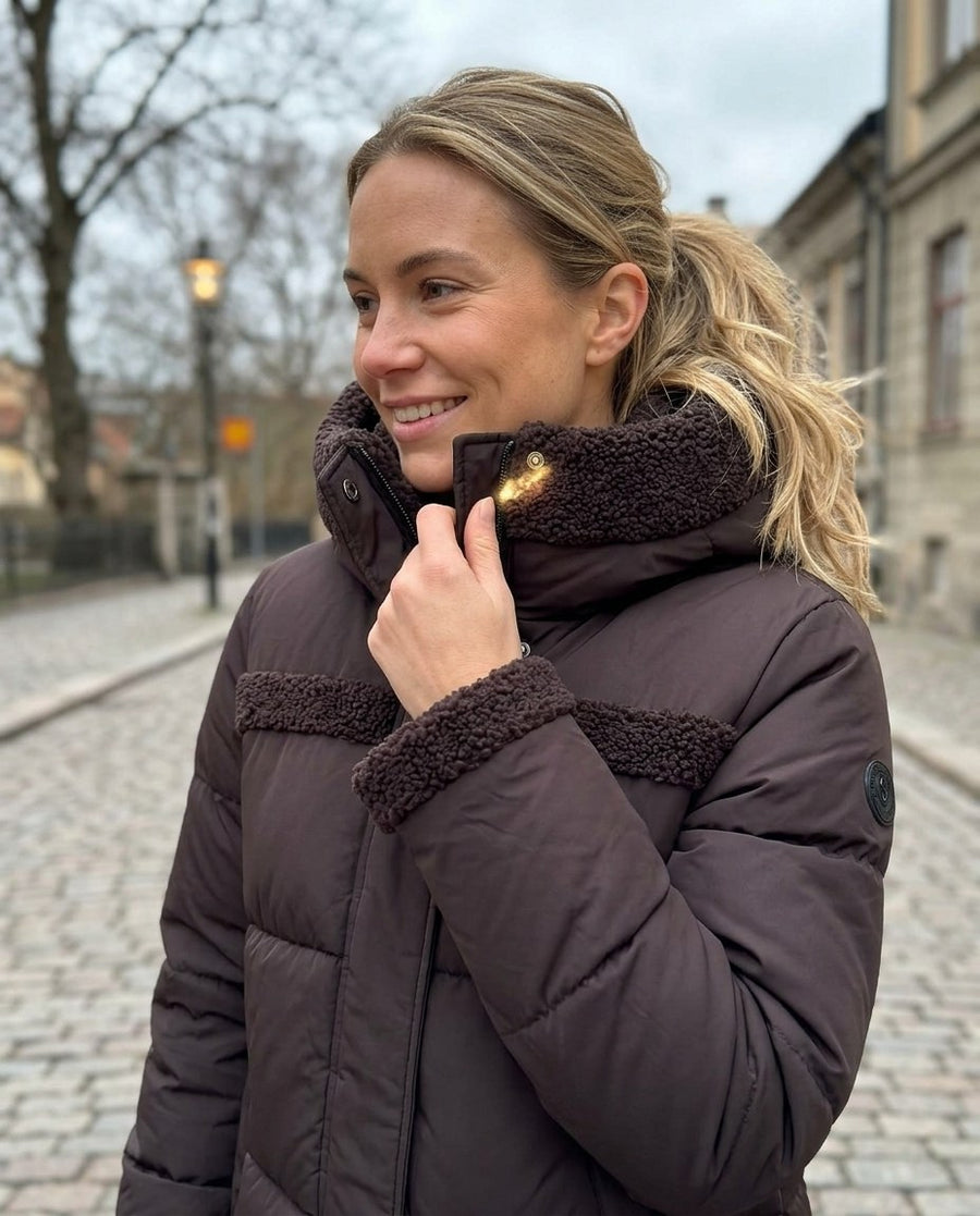 Signe, vadderad 2-i-1-jacka med huva för dam i mörkbrun, stylinginspiration närbild på materialet
