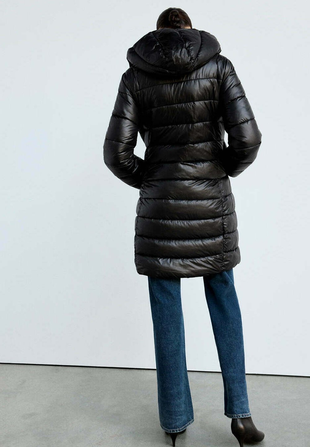 Vera, langer Puffermantel in Schwarz mit Kapuze, von hinten